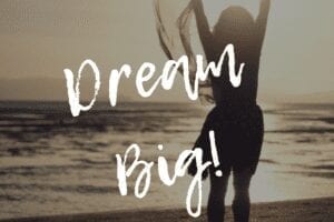 Dream Big quote with woman dancing at the beach in background