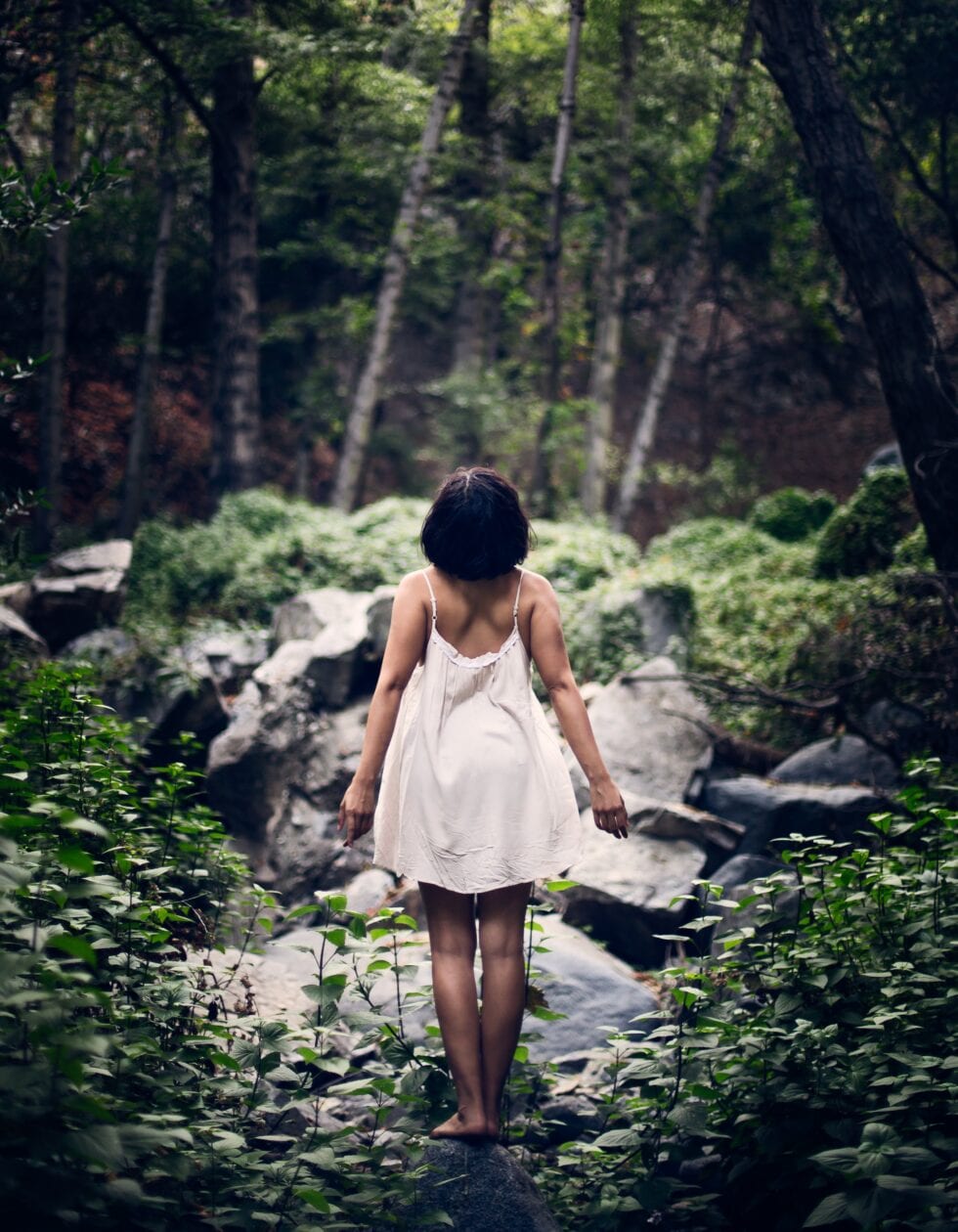 woman with standing in nature with back to camera